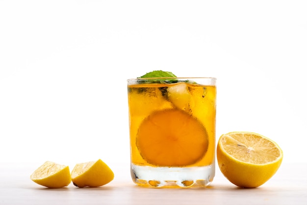 Vista frontal de una bebida de limón con trozos de limón fresco en blanco, color cítrico de frutas