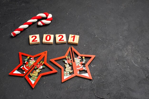 Vista frontal del bloque de madera en forma de estrella adornos de Navidad dulces de Navidad sobre fondo oscuro aislado