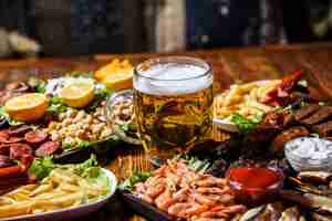 Foto gratuita vista frontal de bocadillos de cerveza con rodajas de limón en un soporte con un vaso de cerveza