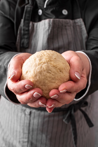 Foto gratuita vista frontal de la bola de masa sostenida por una chef femenina