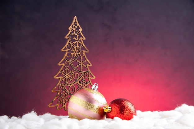 Vista frontal bolas de árbol de Navidad decoración de Navidad sobre fondo rojo.