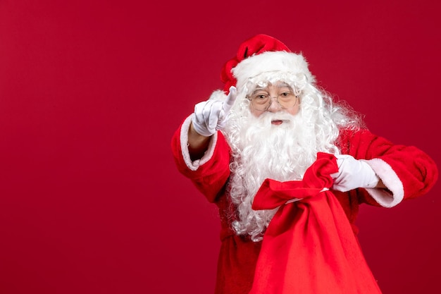 Vista frontal de la bolsa de apertura de santa claus llena de regalos para niños en las emociones navideñas de vacaciones rojas