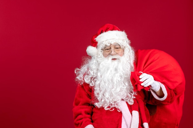 Vista frontal de la bolsa de transporte de santa claus llena de regalos en rojo emoción vacaciones año nuevo