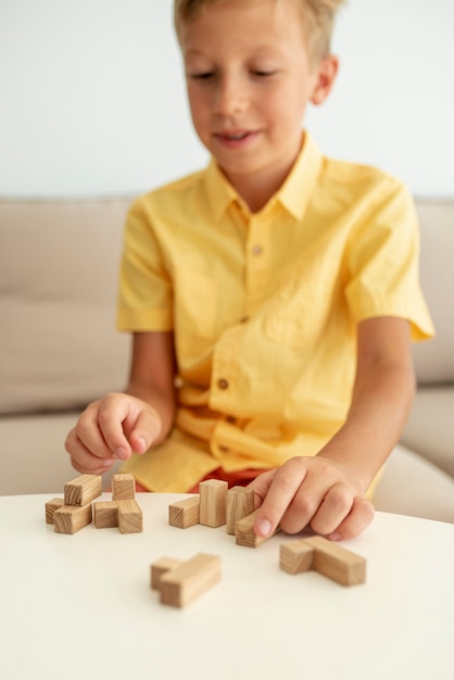 Foto gratuita vista frontal borrosa niño jugando con piezas de jenga