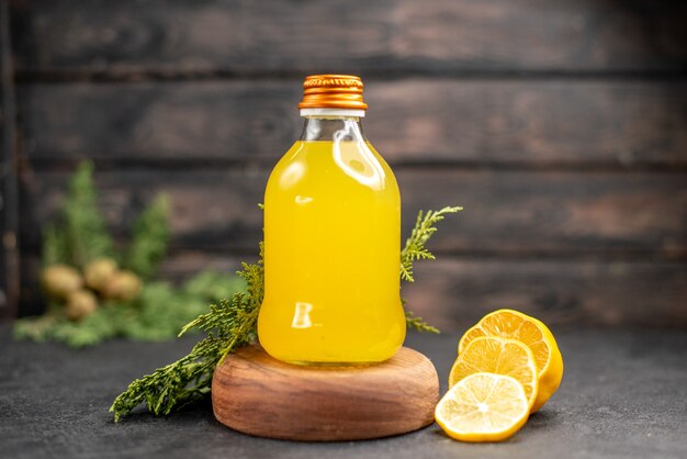 Vista frontal de la botella de jugo de naranja fresco en corte de tablero de madera