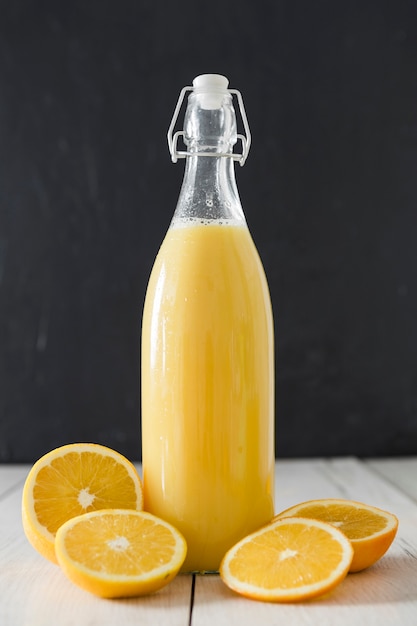 Foto gratuita vista frontal de la botella de jugo de naranja