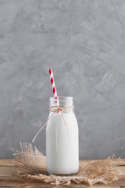 Vista frontal botella de leche con paja