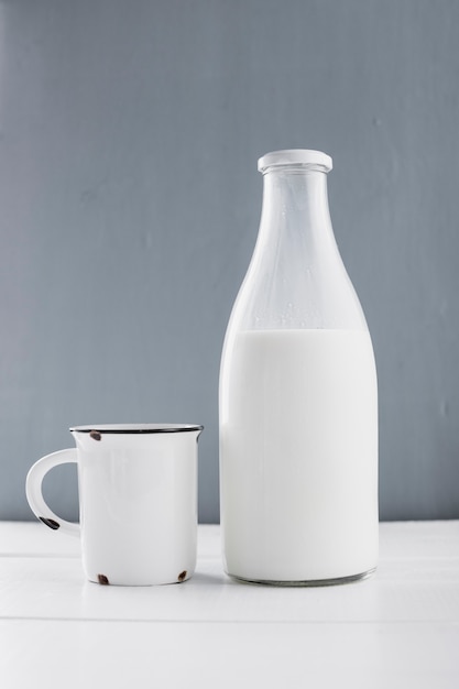 Vista frontal botella de leche con taza