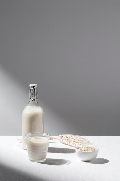 Vista frontal de la botella de leche con vaso lleno y espacio de copia