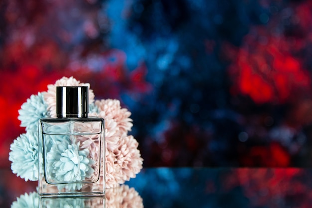 Vista frontal de la botella de perfume flores sobre fondo de acuarela rojo azul oscuro espacio libre