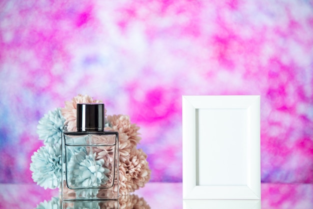 Vista frontal botella de perfume pequeñas flores de marco de imagen blanca sobre fondo rosa borroso