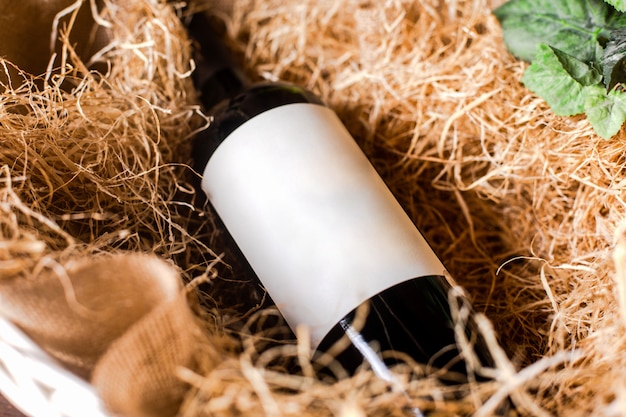 Una vista frontal botella de vino tinto en el heno