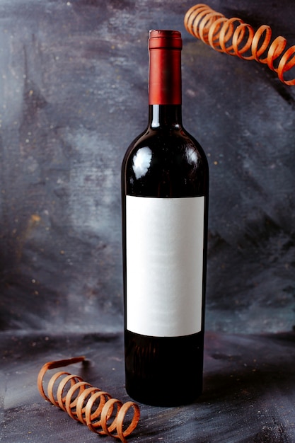 Foto gratuita vista frontal botella de vino tinto negro en el piso brillante