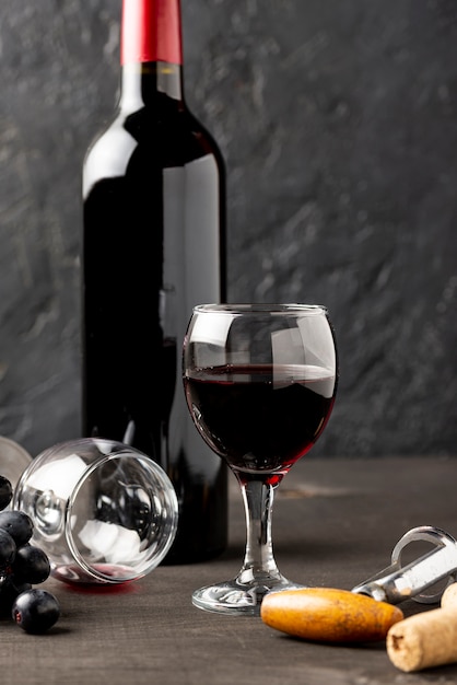 Vista frontal botella de vino tinto y vasos