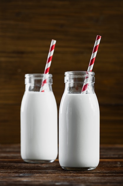 Vista frontal botellas de leche con pajitas