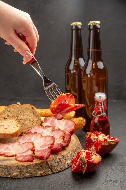 Vista frontal de las botellas de oso con lonchas de jamón y pan sobre un fondo oscuro