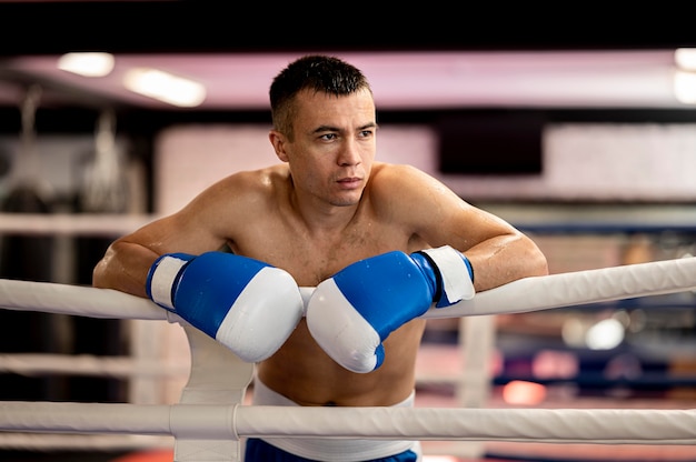 Vista frontal del boxeador masculino sin camisa en el ring