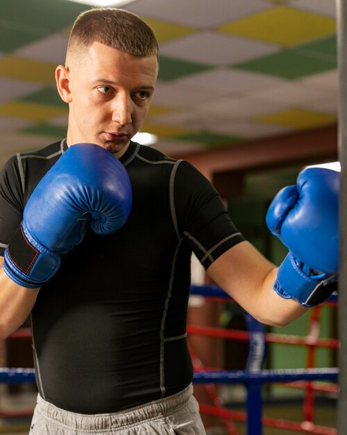 Vista frontal del boxeador masculino con guantes de entrenamiento