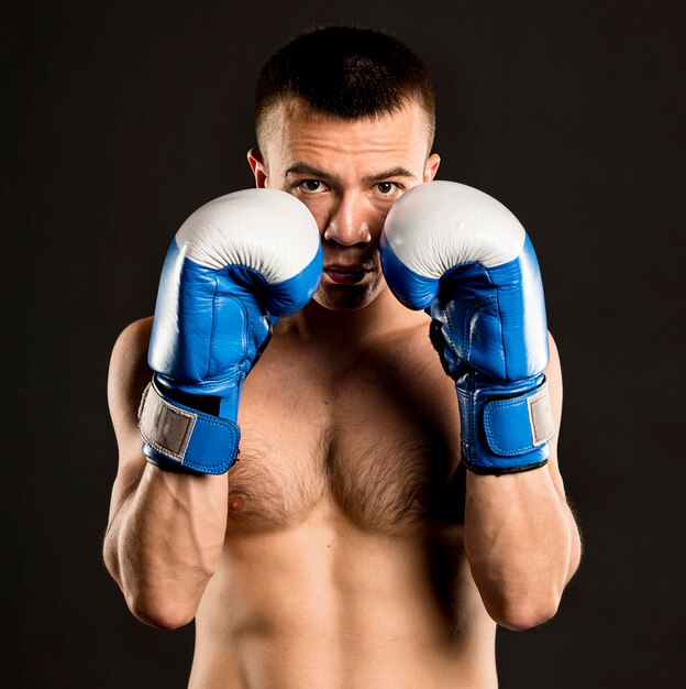 Foto gratuita vista frontal del boxeador masculino posando con guantes protectores