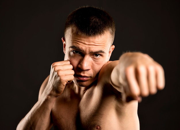 Vista frontal del boxeador masculino posando con postura de boxeo