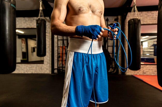 Vista frontal del boxeador masculino con saltar la cuerda