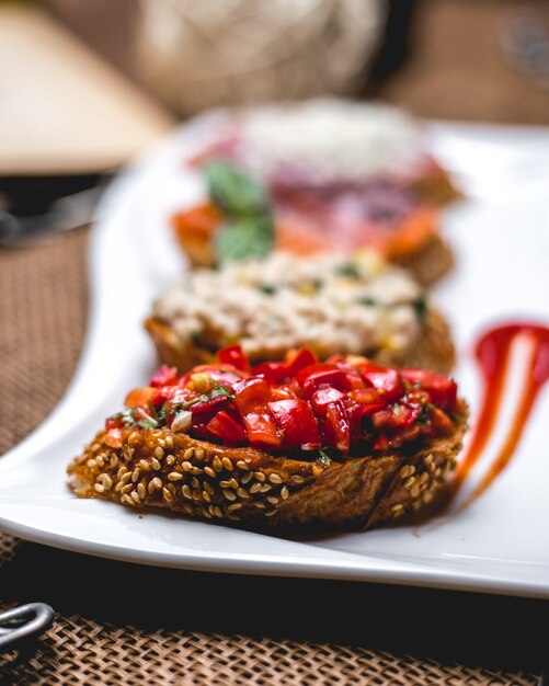 Vista frontal bruschetta con semillas de sésamo y tomates