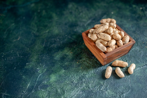 Foto gratuita vista frontal de cacahuetes frescos sobre nueces azul oscuro bocadillos de avellana cips fotos en color de nuez