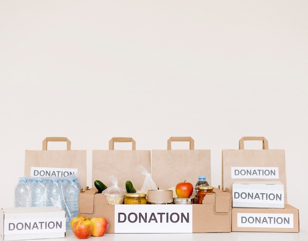 Vista frontal de cajas y bolsas de donación con espacio de copia