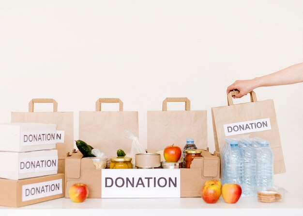 Vista frontal de cajas de donación y bolsas con comida