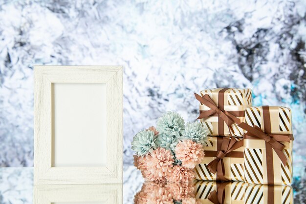 Vista frontal cajas de regalo de vacaciones marco de imagen vacía flores reflejadas en el espejo
