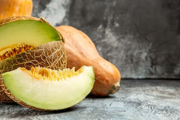 Vista frontal de calabaza fresca con melón sobre un fondo claro oscuro