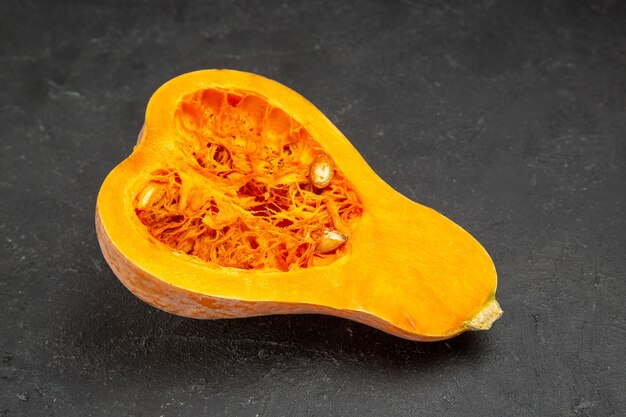 Vista frontal de calabaza fresca en rodajas en mesa oscura fruta naranja