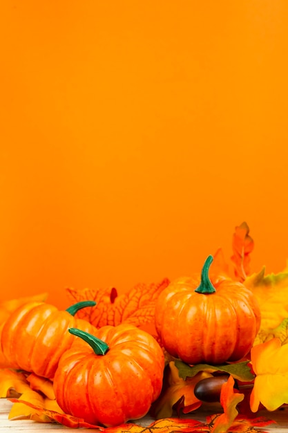 Foto gratuita vista frontal de calabazas con fondo naranja