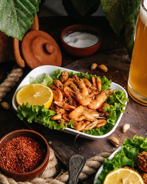 Una vista frontal de camarones fritos con ensalada de limón y verde en la mesa comida comida mariscos cáncer