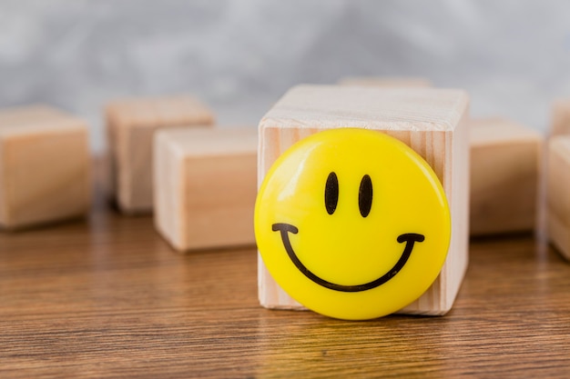 Vista frontal de la cara sonriente en bloque de madera