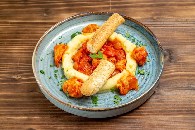 Vista frontal de carne salteada con puré de patatas y pan en rodajas en la mesa de madera marrón carne pan comida de patata