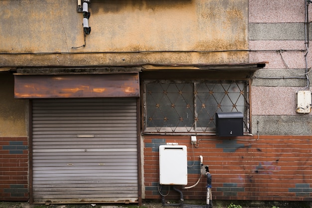 Vista frontal casa abandonada con puerta oxidada