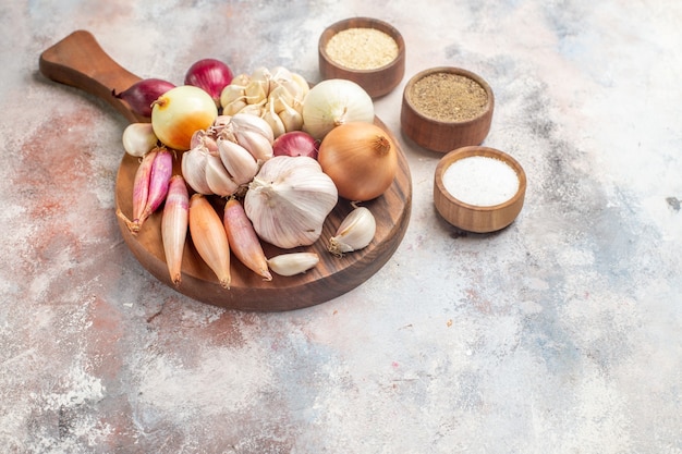 Vista frontal cebollas y ajos ingredientes frescos con condimentos