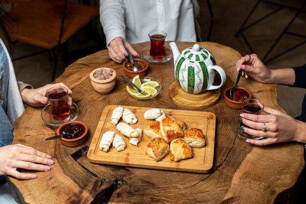 Una vista frontal cerca de la ceremonia del té amigos bebiendo té caliente y comiendo mermelada