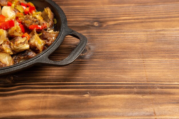 Vista frontal cercana comida vegetal cocida con carne en el escritorio de madera marrón