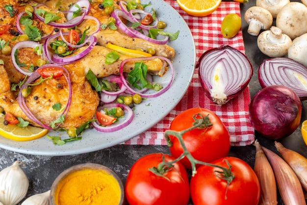 Vista frontal cercana de una deliciosa cena plato de pollo frito con varias especias y alimentos ajos botella de aceite caída cebollas de limón champiñones kumquats