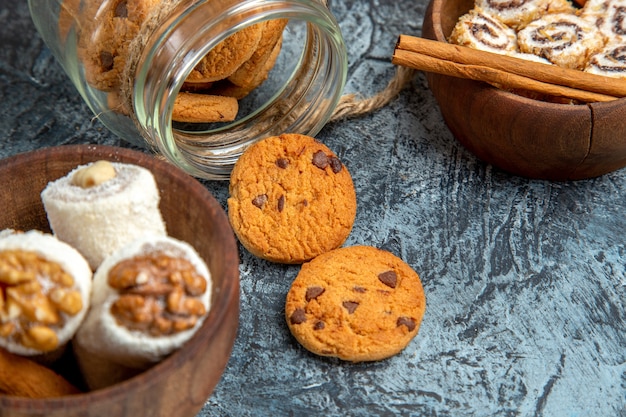 Vista frontal cercana de galletas dulces con confituras en superficie oscura