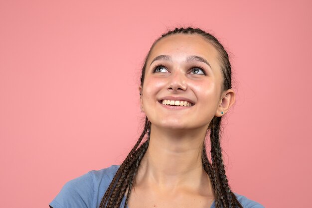 Vista frontal cercana de la joven sonriendo felizmente en rosa