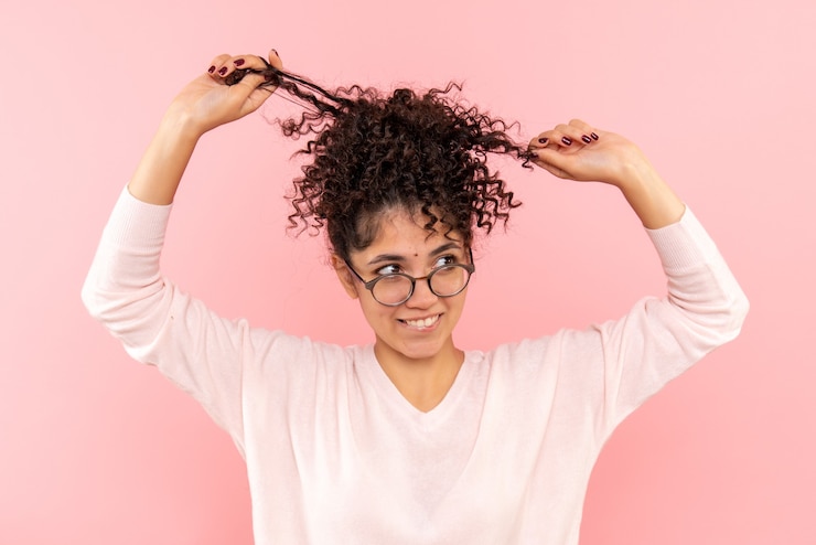 Foto gratuito vista frontal cercana de las mujeres jóvenes jugando con su cabello en rosa