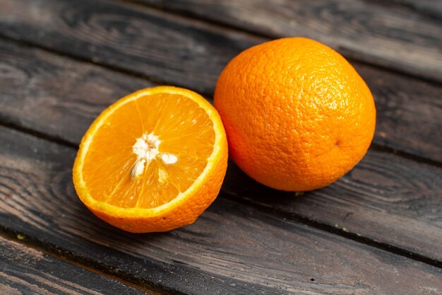 Vista frontal cercana naranjas agrias frescas jugosas y suaves aisladas en el fondo rústico marrón fruta cítrica trópico jugo agrio fresco