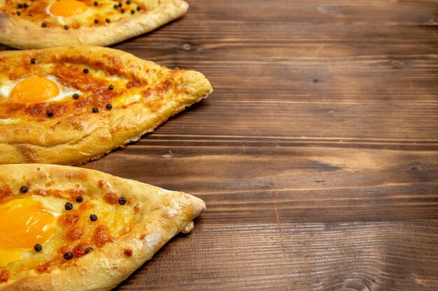 Vista frontal cercana panes de huevo horneados recién salidos del horno en un escritorio de madera marrón masa de pan de huevo desayuno