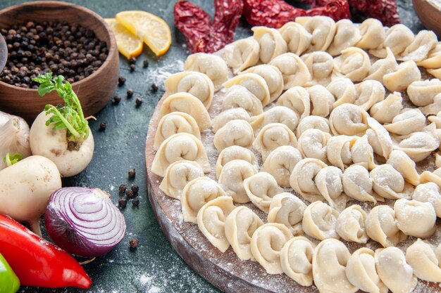 Vista frontal cercana pequeñas albóndigas crudas con harina y verduras en la masa de carne oscura plato de comida comida calórica color hornear vegetales