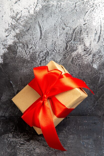 Vista frontal cercana del regalo de Navidad con cinta roja