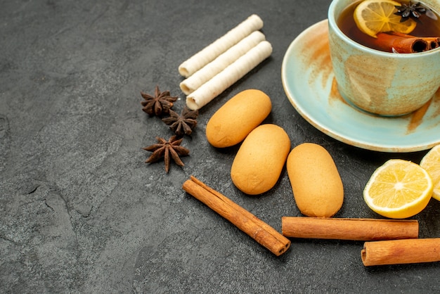 Foto gratuita vista frontal cercana taza de té con limón y galletas en la mesa gris galleta galleta dulce