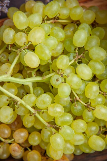 Vista frontal cercana uvas suaves frescas en la superficie oscura vino uva fresca planta de árboles frutales maduros
